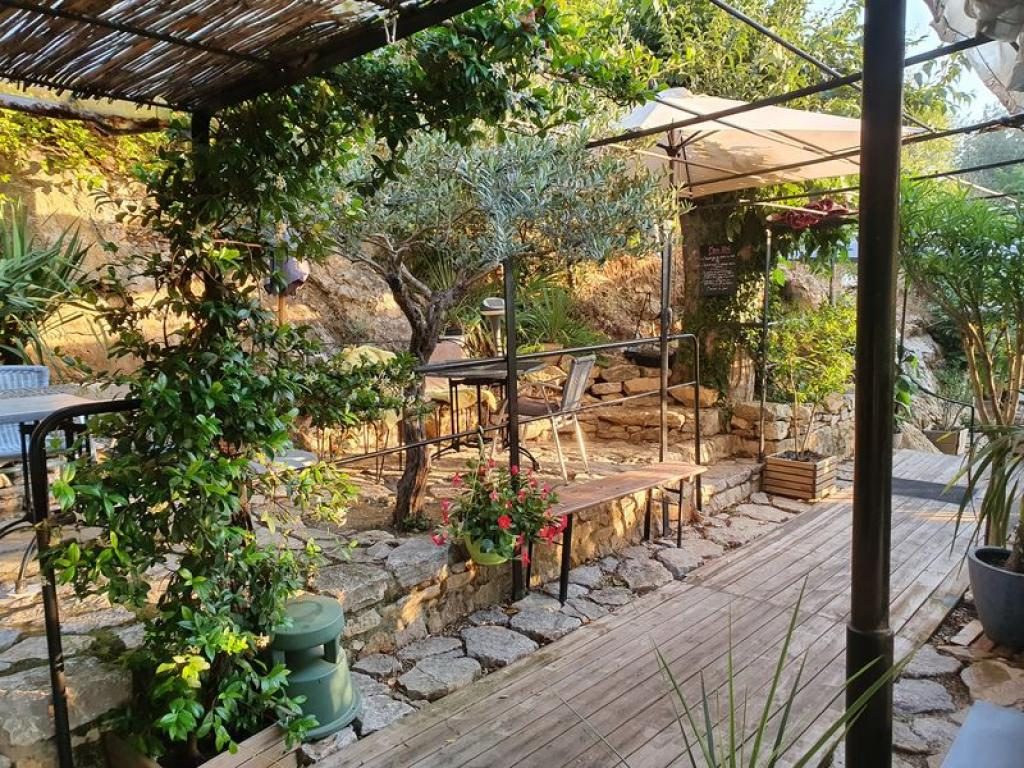 Une allée en bois sous une pergola, bordée de tables